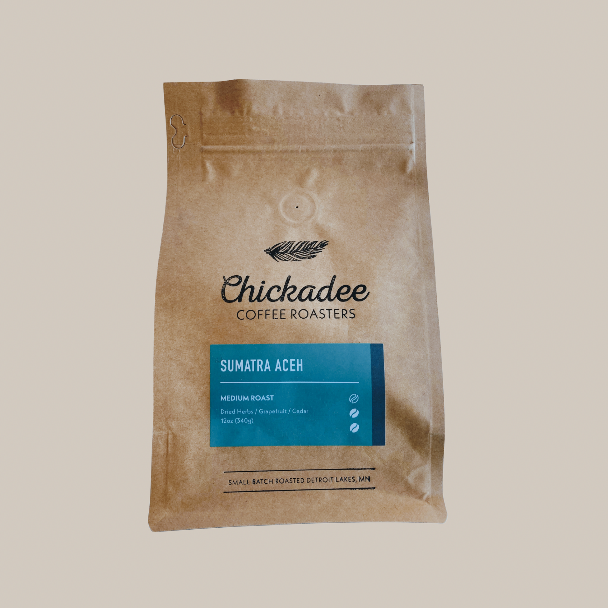 A brown bag of Chickadee Coffee Roasters Sumatra Aceh medium roast coffee, with dried herbal, grapefruit, and cedar notes from the Gayo Highlands, set against a neutral background.
