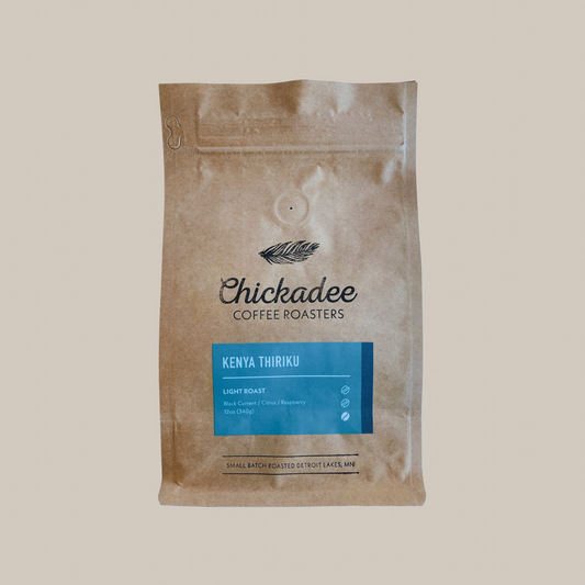 A brown paper bag from Chickadee Coffee Roasters labeled Kenya Thiriku, a light roast with flavor notes of black currant, citrus, and blueberry from the renowned Nyeri region.