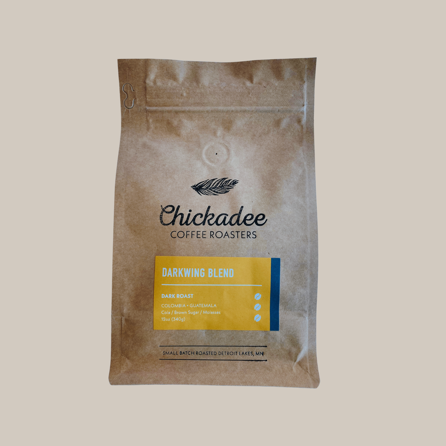 A brown Chickadee Coffee Roasters Variety Bundle (4 Pack) coffee bag with a yellow label and brand logo displayed on a plain beige background.